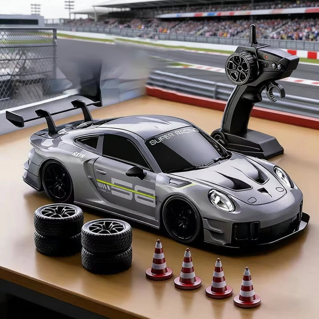A gray remote control race car with a black rear wing and decals, shown on a tabletop with a black handheld controller, four black tires, and four red-and-white cones. A blurred racetrack scene appears in the background, along with text reading 'High-power race car' and battery icons.